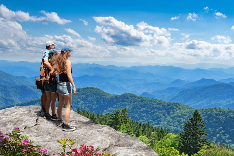 family on cliff overlooking the Smoky Mountains