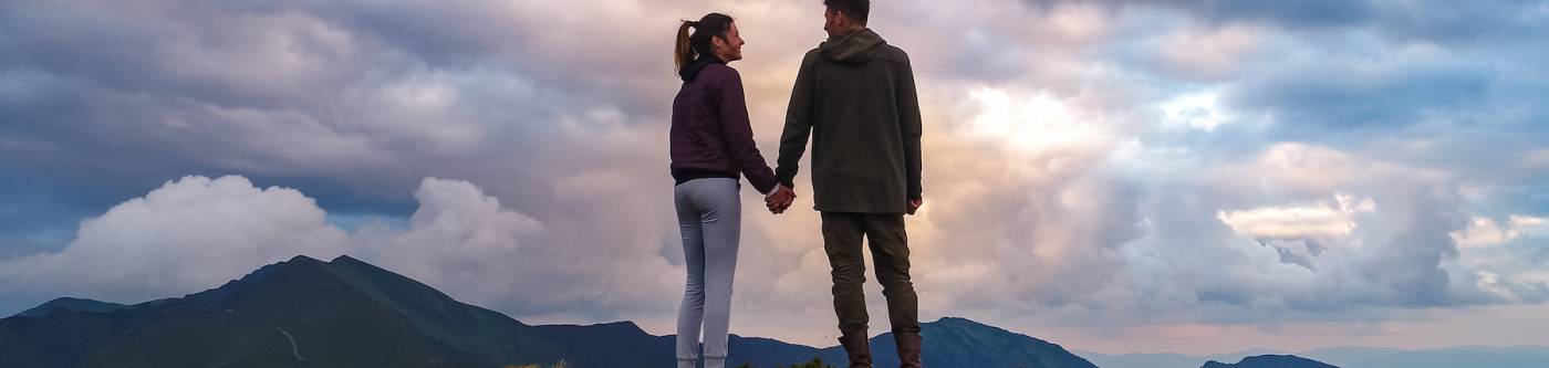 couple standing atop a mountain 