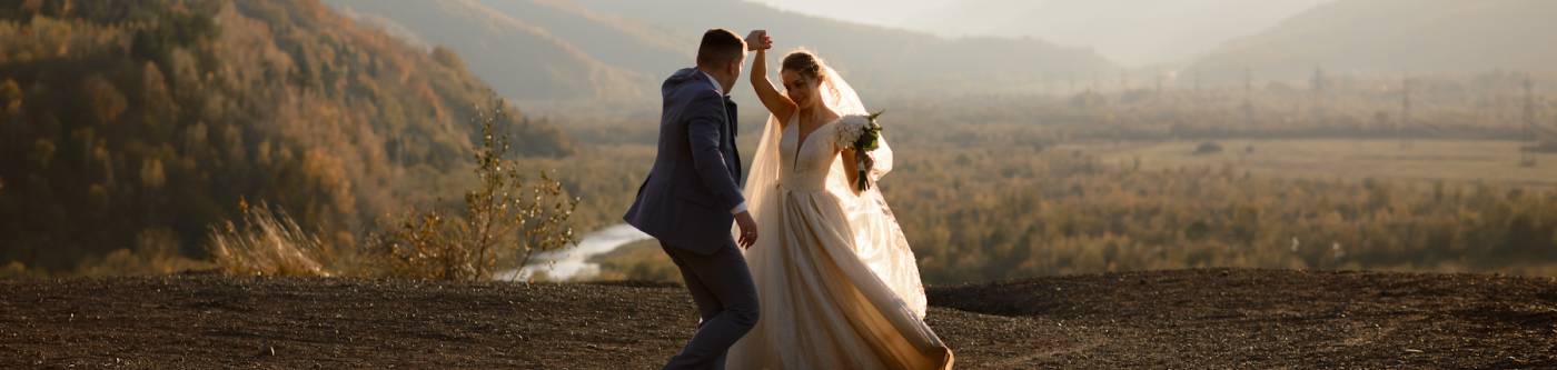 married couple dancing with mountains in background